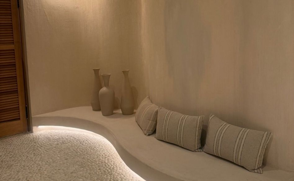Curved built-in seating with striped cushions and soft wall lighting
